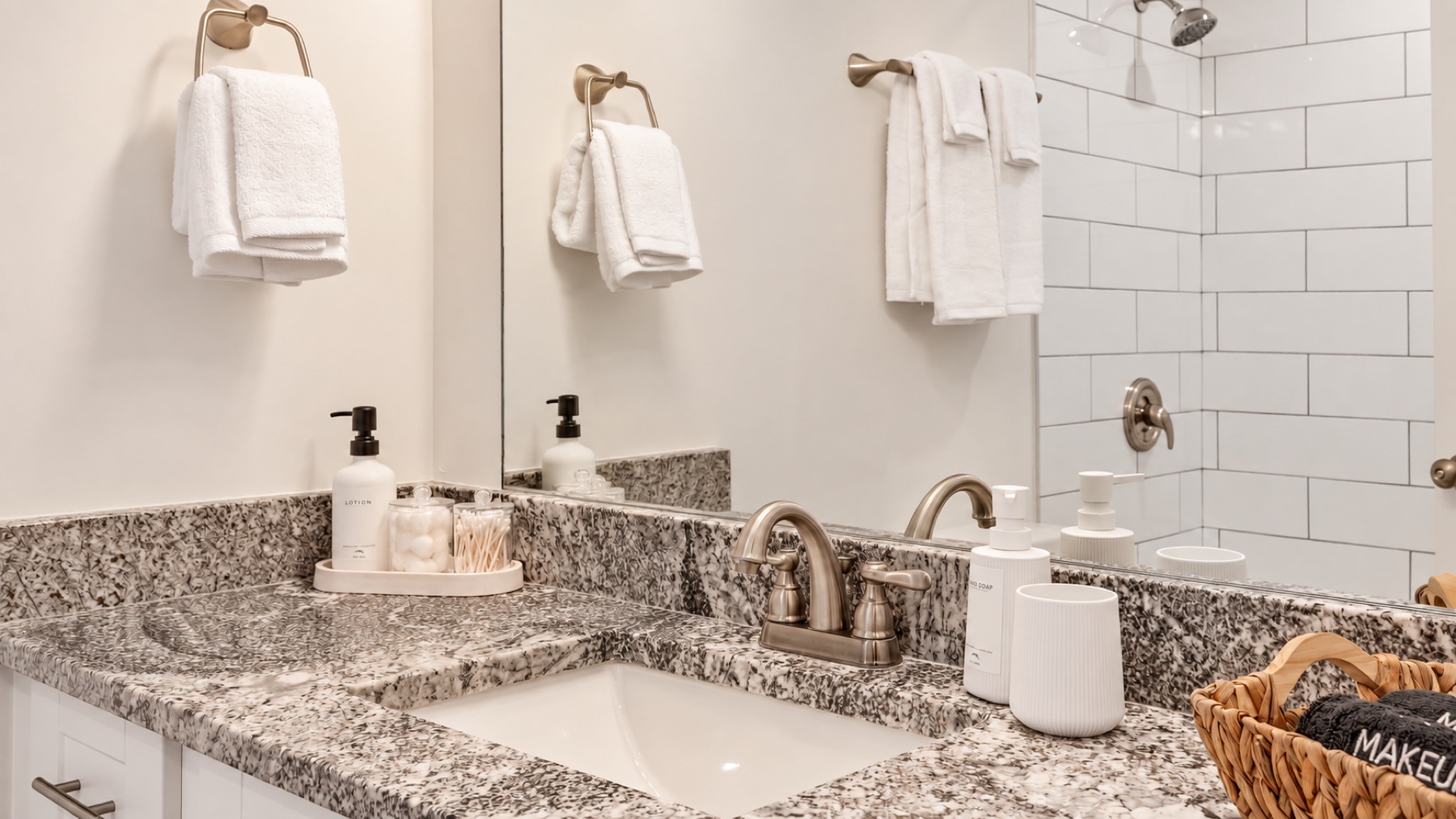The vanity, close: granite, brushed-nickel taps, and towels folded where you can reach them.