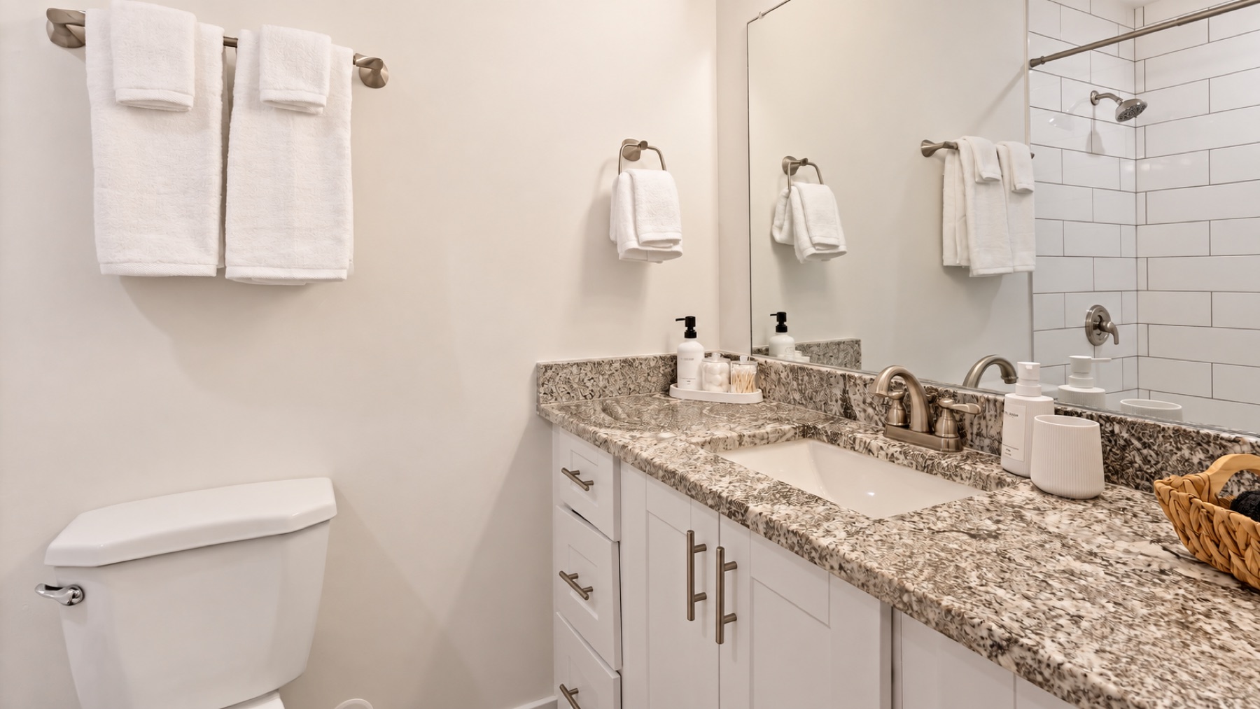 The same bath from the door, with the toilet at the left and the shower in the mirror.