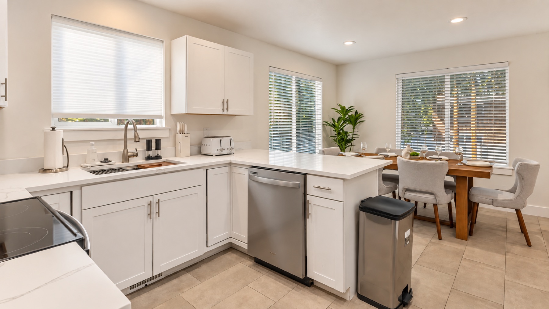 The kitchen counter and its peninsula, with the dining table and its grey chairs just past the bar.