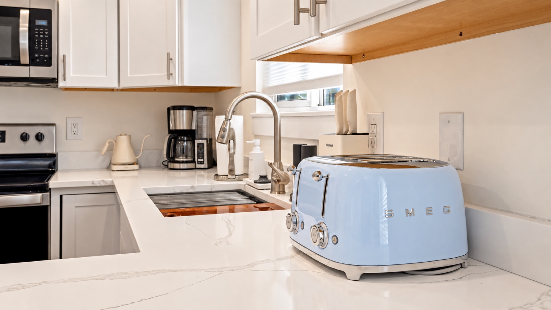 The counter's one bright thing: a blue Smeg toaster, with the coffee maker and the kettle in reach.