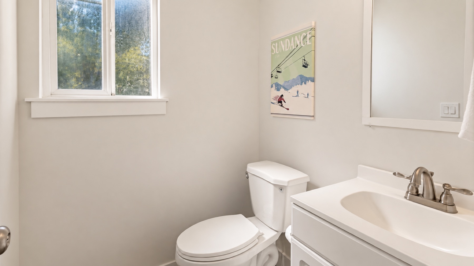 The half bath on the main floor, with its own window and a ski poster over the toilet.