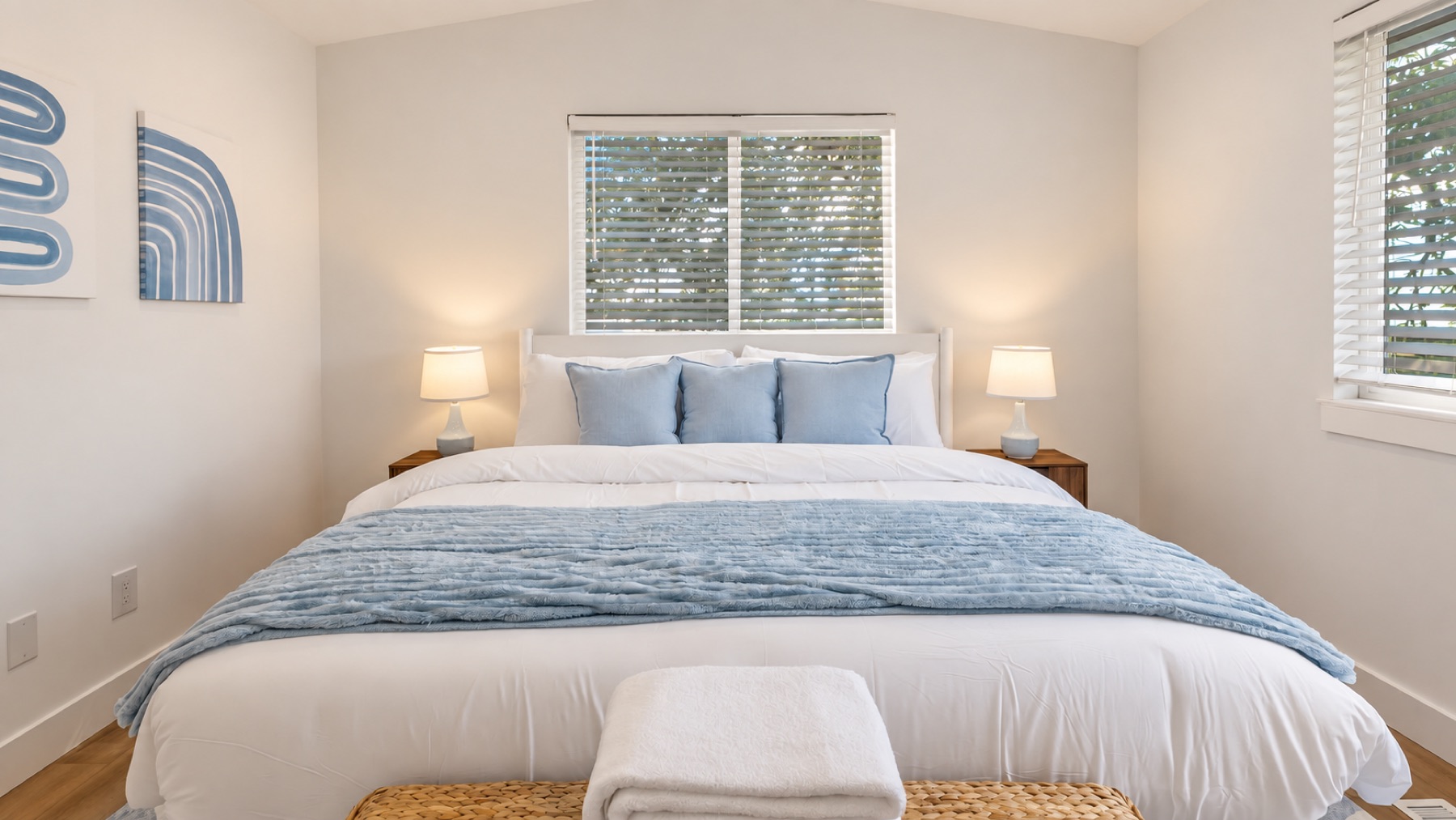 The primary from the door, reading lamps on both sides and the line-art print above the bed.