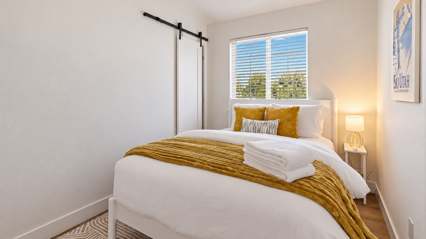 Bedroom three, in gold, behind a barn door, with the Sundance print keeping watch.