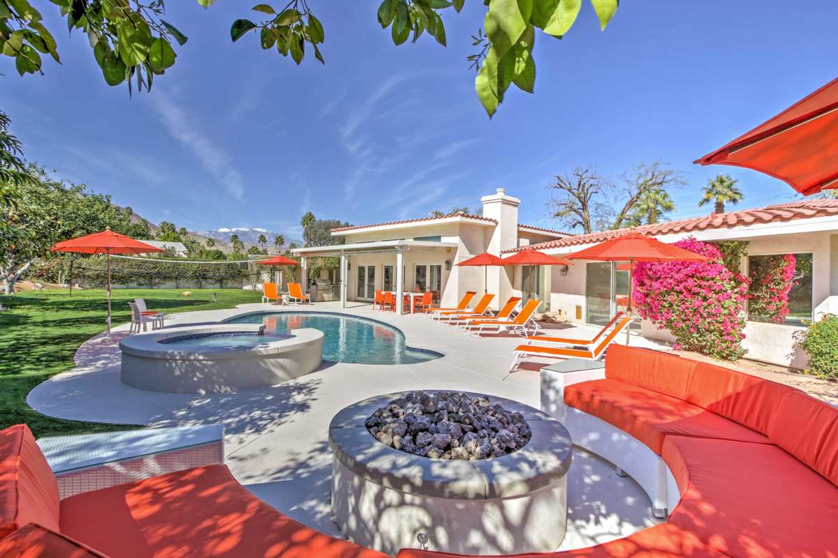 Juniper House at golden hour — red umbrellas, bougainvillea, spa and firepit