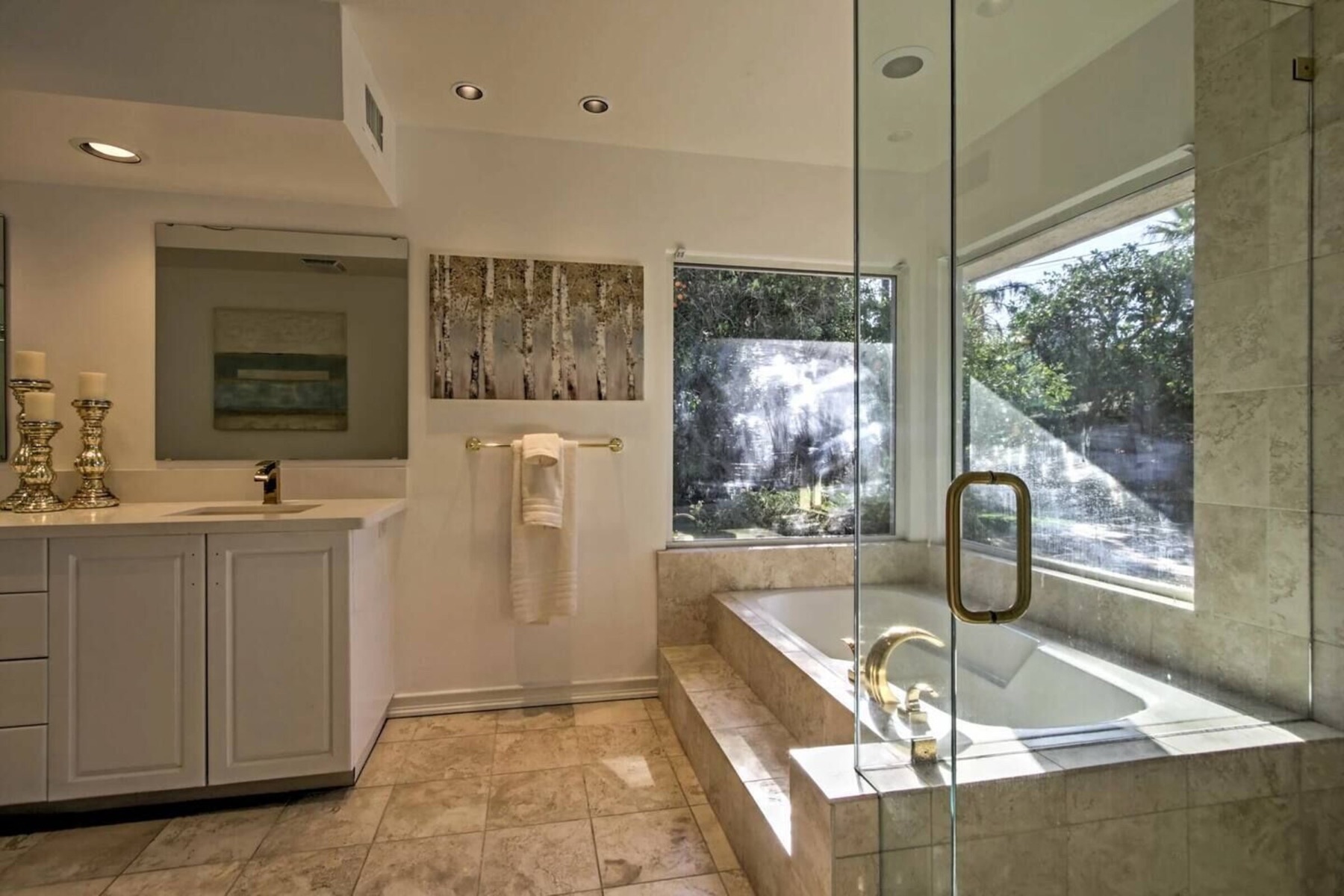 The primary bath — soaking tub by the window, glass shower