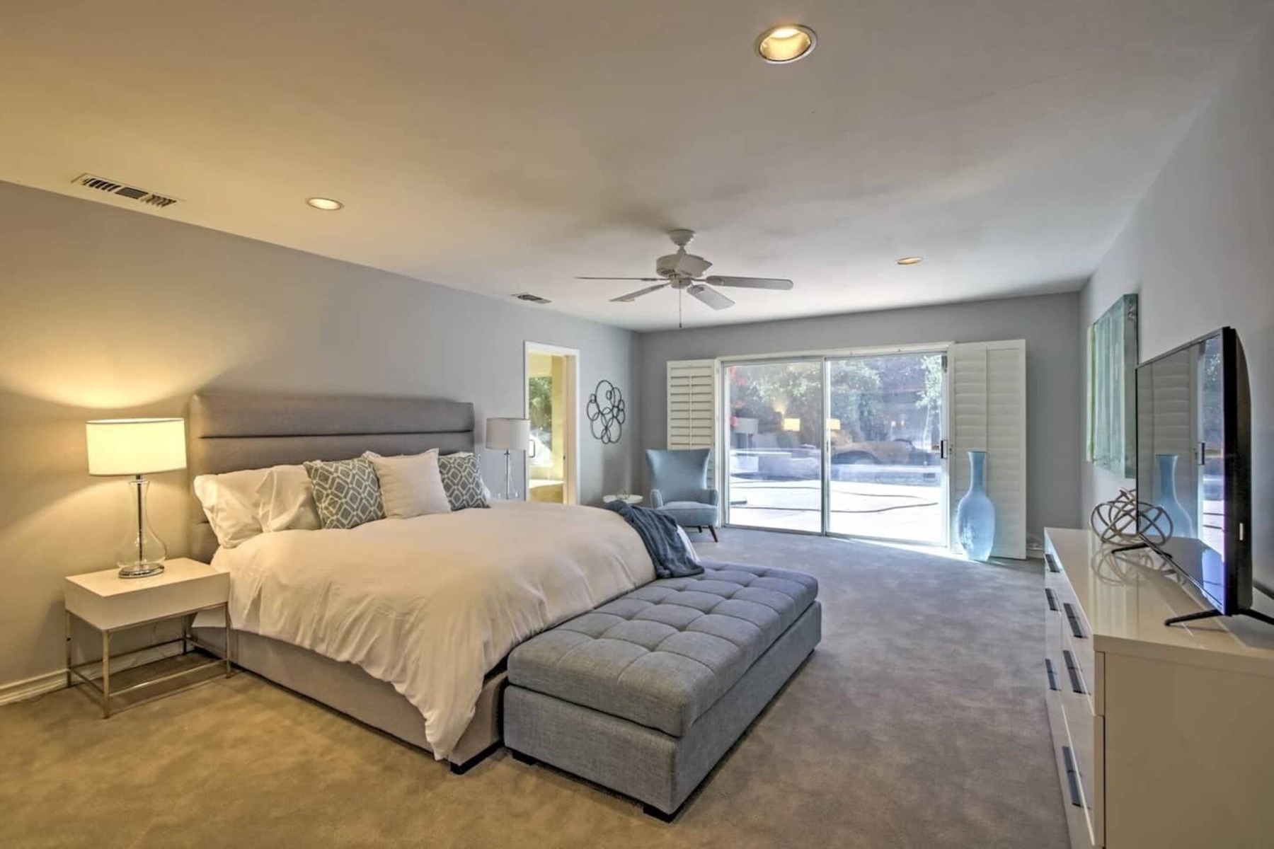 The primary suite — king bed with a view through the glass door