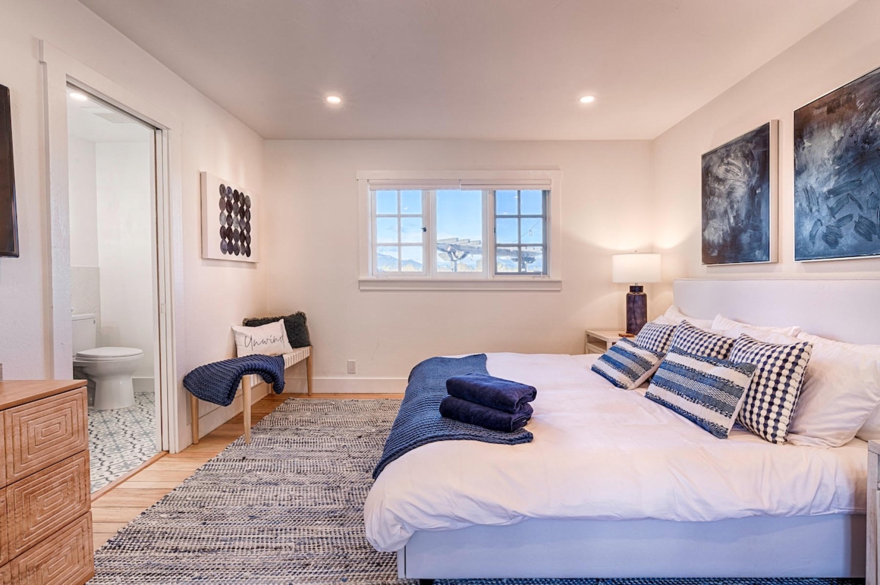 The primary suite — a king bed under the plank ceiling
